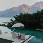 Relax by a serene infinity pool overlooking mountains and the ocean.