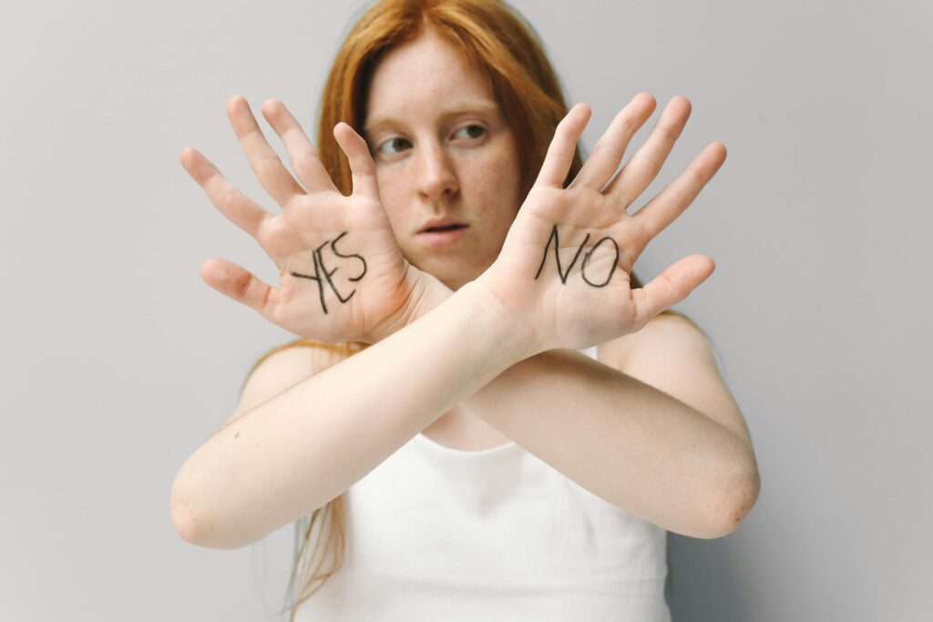 A woman shows 'YES' and 'NO' on her palms, symbolizing decision-making.